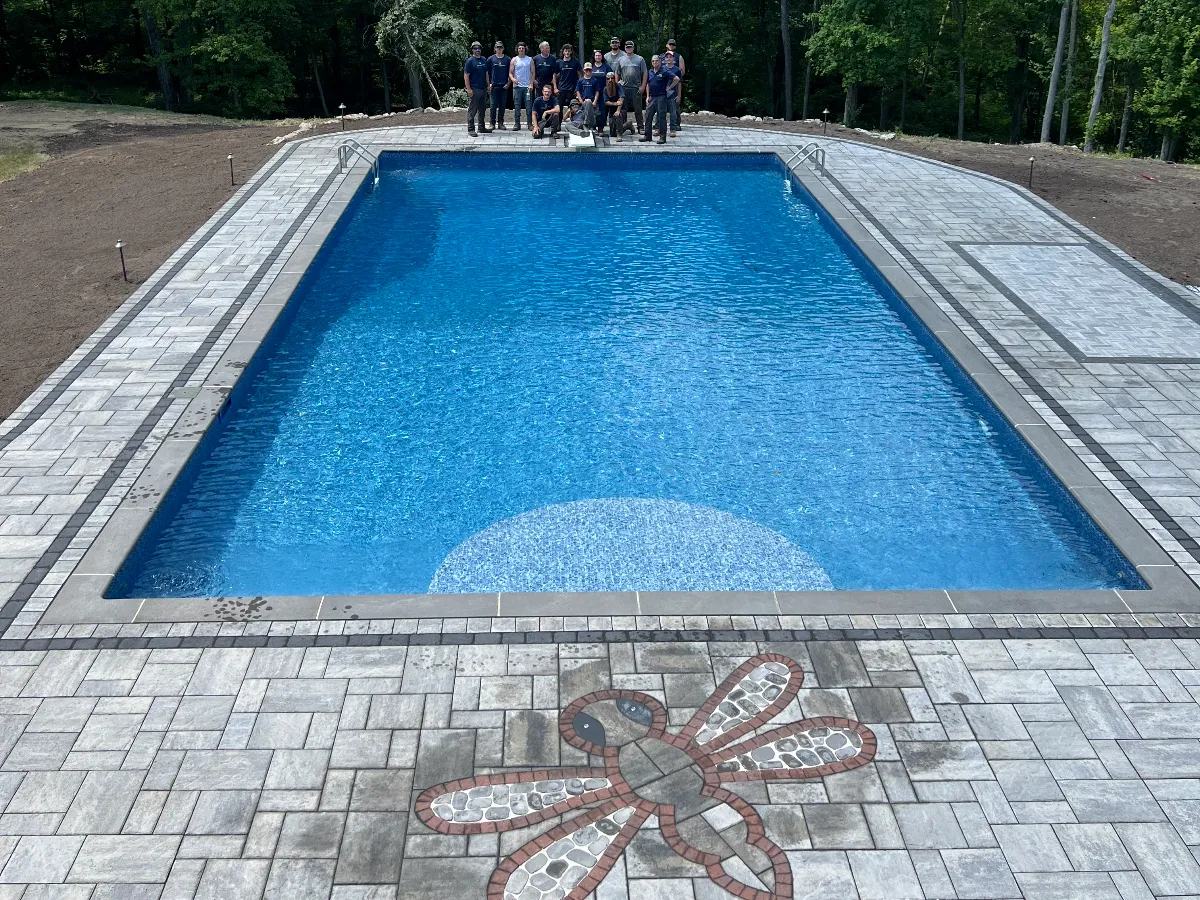 New pool and pool deck with the JB's landscape crew in the background in Knowlton, New Jersey.