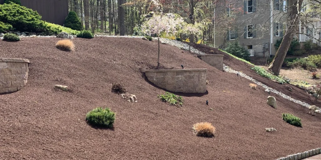 Sloped backyard patio retaining wall in Hope, New Jersey